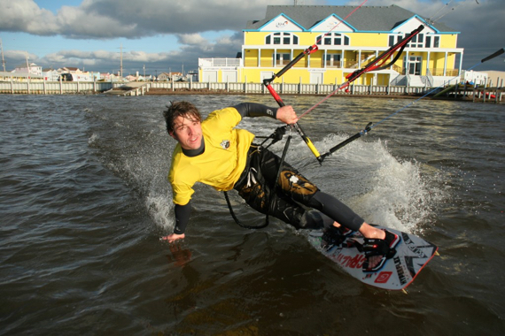 Kiteboarding on a cool day with Waves Village Resort in the background.