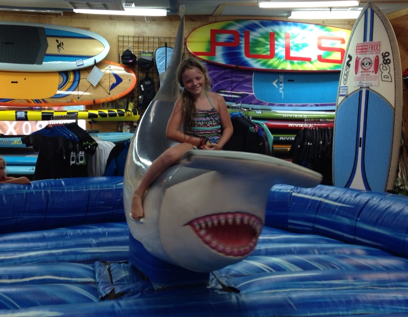 Girl riding the mechanical shark at kids days