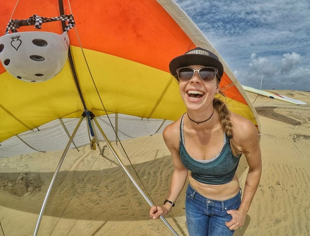 Pilot Sara Weaver in front of a hang glider at the Hang Gliding Spectacular Comp