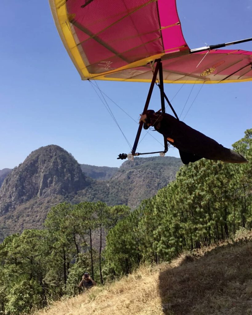 Sara launching her hang glider in Mexico with El Peñón in the background.